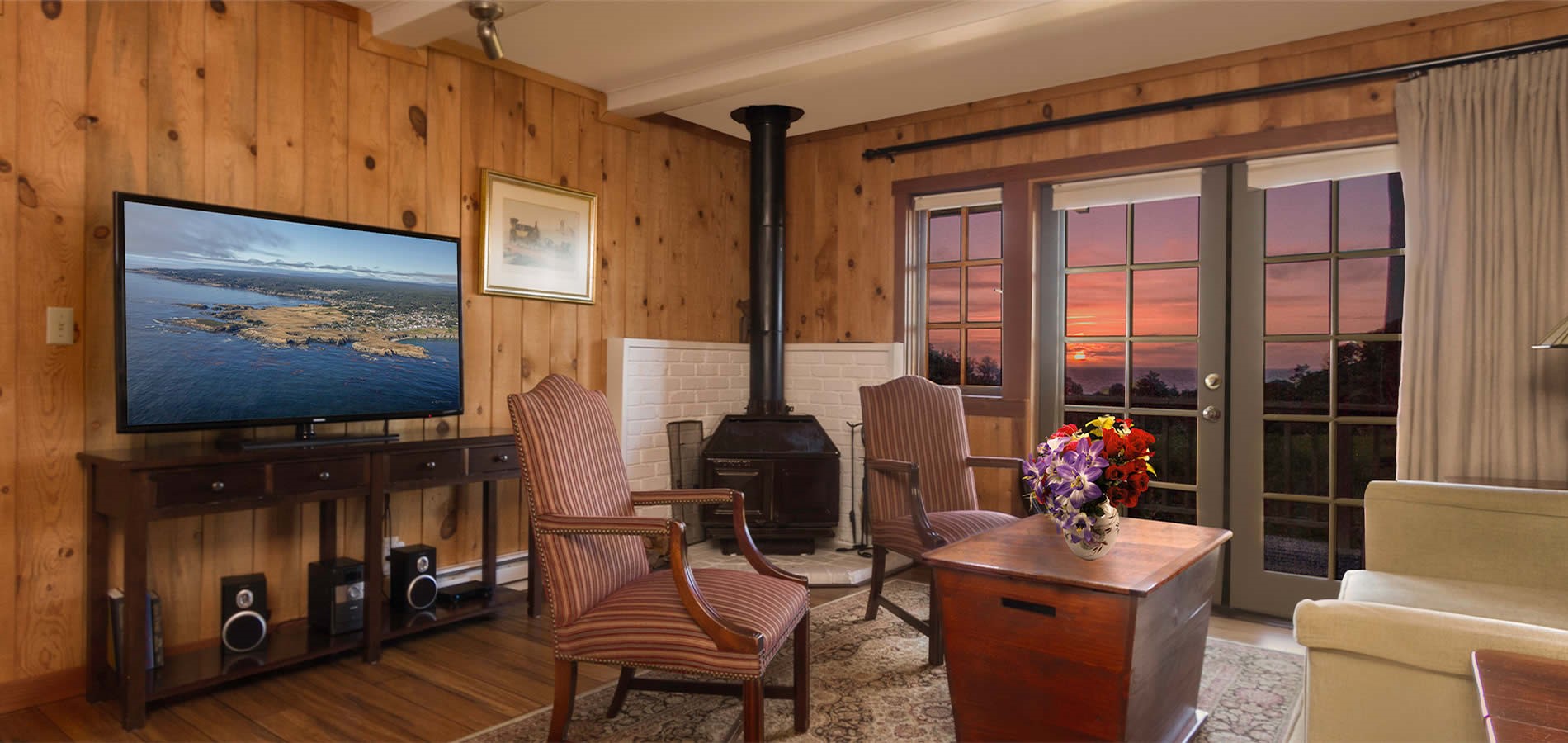 guest room with TV, couch and sunset in background
